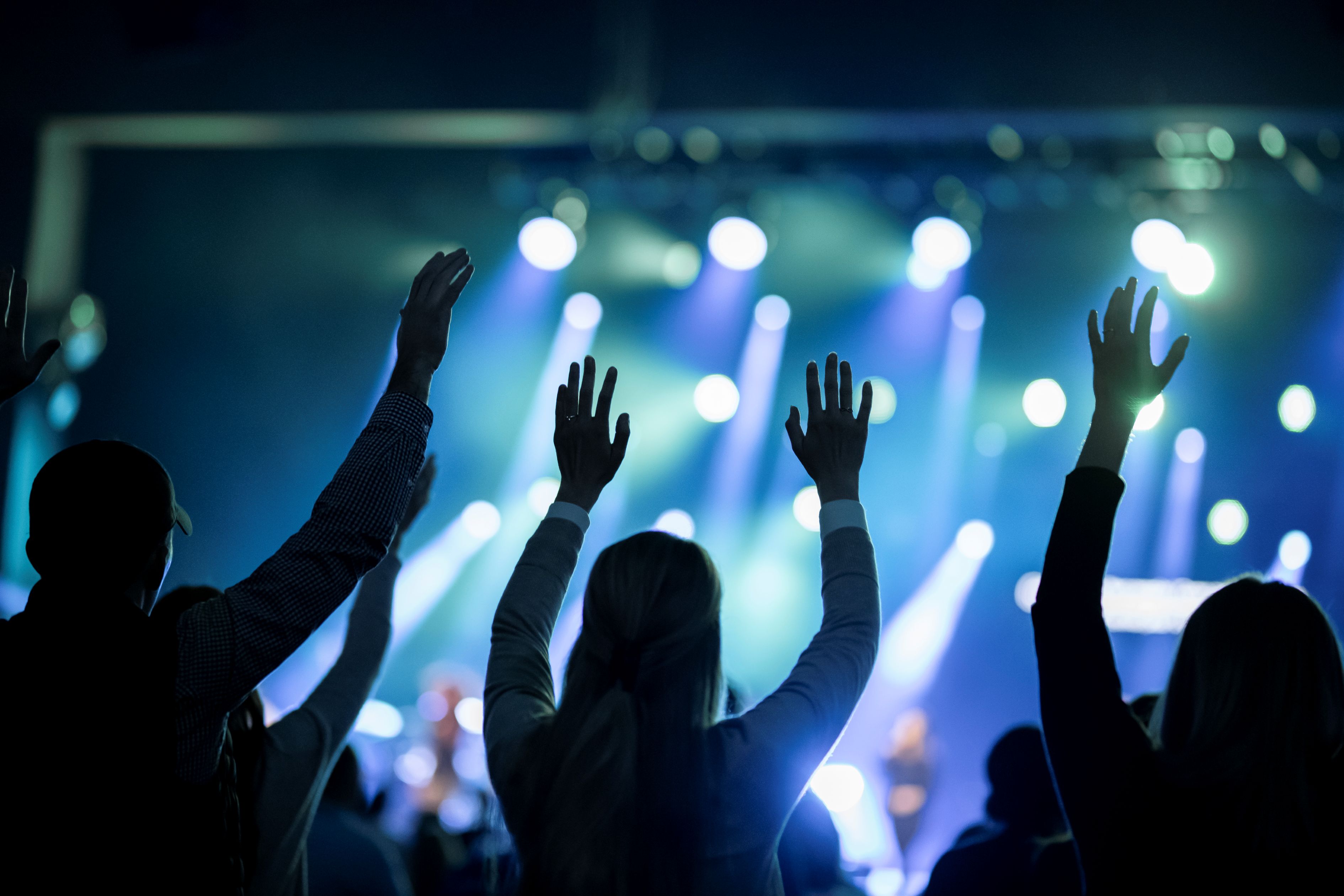 Women in a crowd with their hands up