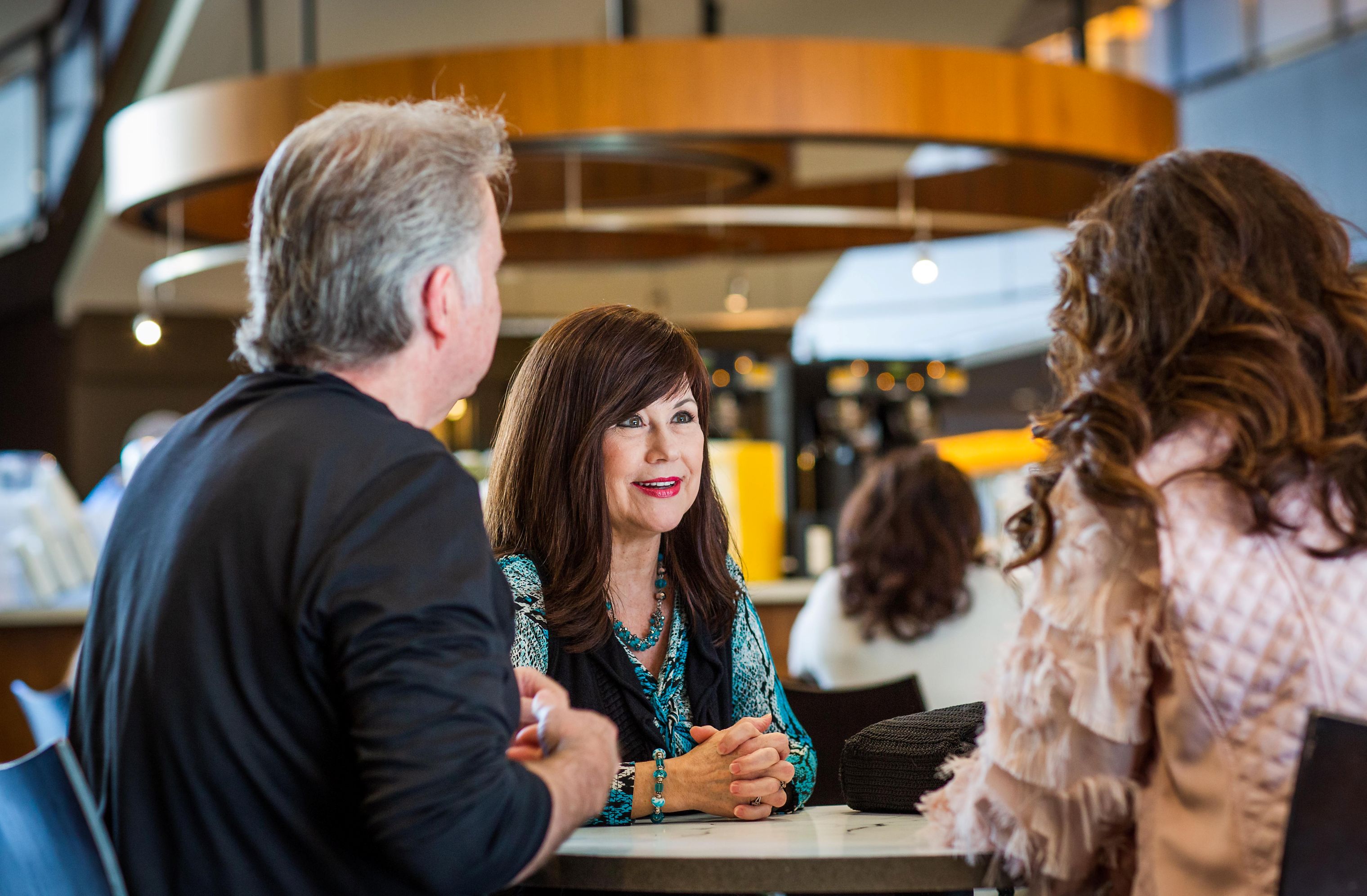 Woman speaking to two people at a table
